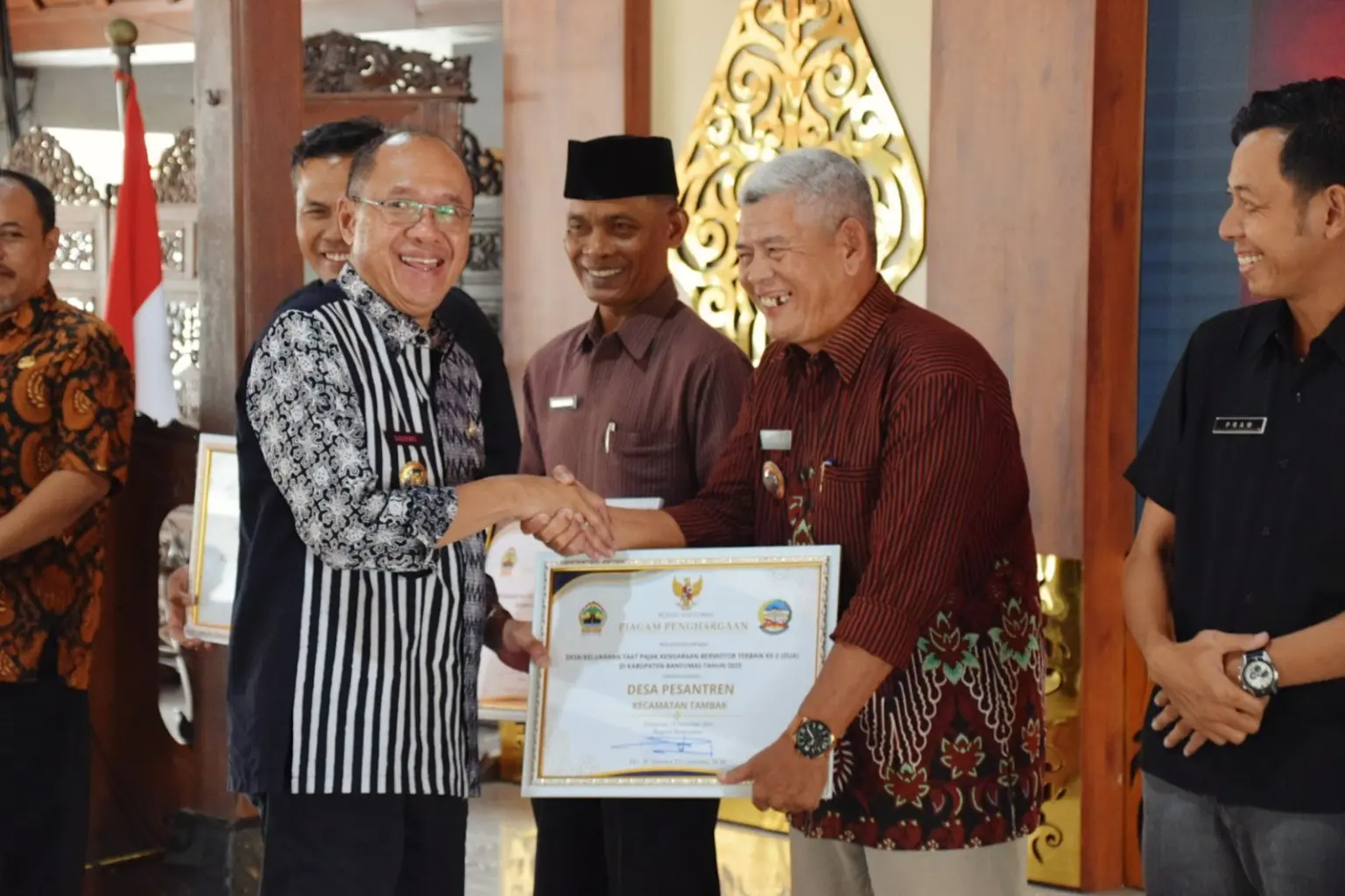 Bupati Banyumas, Sadewo Tri Lastiono, menyerahkan secara simbolis Penghargaan Optimalisasi PKB 2025 di Pendopo Si Panji, Purwokerto, Kamis (18/12/2025).