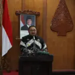 Wabup Dimas Prasetyahani menyampaikan paparan dalam High Level Meeting (HLM) Tim Pengendalian Inflasi Daerah (TPID) dan Tim Percepatan dan Perluasan Digitalisasi Daerah (TP2DD) Kabupaten Purbalingga,di Operation Room Graha Adiguna,Selasa (16/12/2025). (Foto: Budi Pekerti).