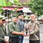 Bupati Fahmi Muhammad Hanif menyerahkan bibit tanaman kepada perwakilan kelompok masyarakat, Sabtu (27/12/2025). (Foto: Prokopim Setda Purbalingga).