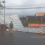 Petugas dan warga saat evakuasi atap rumah makan yang terbang ke jalan akibat hujan dan angin kencang. (BPBD Cilacap).