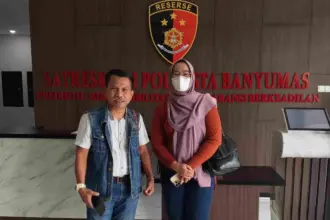 Perempuan berinisial Vi, istri polisi yang menjadi korban KDRT, bersama kuasa hukum Djoko Susanto, usai pelaporan di Polresta Banyumas.