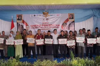 Kepala Badan Percepatan Pengentasan Kemiskinan, Budiman Sudjatmiko, menyerahkan program SiTaskin kepada Bupati Cilacap Syamsul Auliya Rachman. (Faiz Ardani).