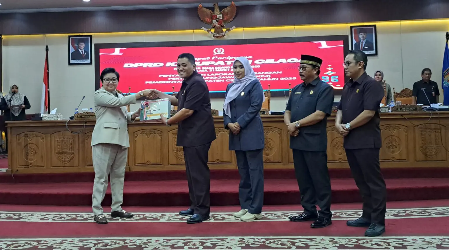 Plt Bupati Cilacap Ammy menyerahkan dokumen LKPJ Cilacap 2025 kepada Ketua DPRD Taufik Nurhidayat didampingi para wakil ketua. (Faiz Ardani).