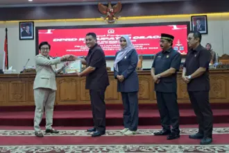 Plt Bupati Cilacap Ammy menyerahkan dokumen LKPJ Cilacap 2025 kepada Ketua DPRD Taufik Nurhidayat didampingi para wakil ketua. (Faiz Ardani).