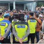 Polisi saat mengamankan aksi warga Desa Gununggiana