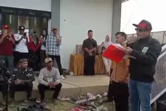 Kades Hoho didampingi Ketua BPD saat membacakan komitmen melantik perades terpilih dihadapan ratusan warga Purwasaba, Selasa (12/5/2026). (Foto: Heri C)