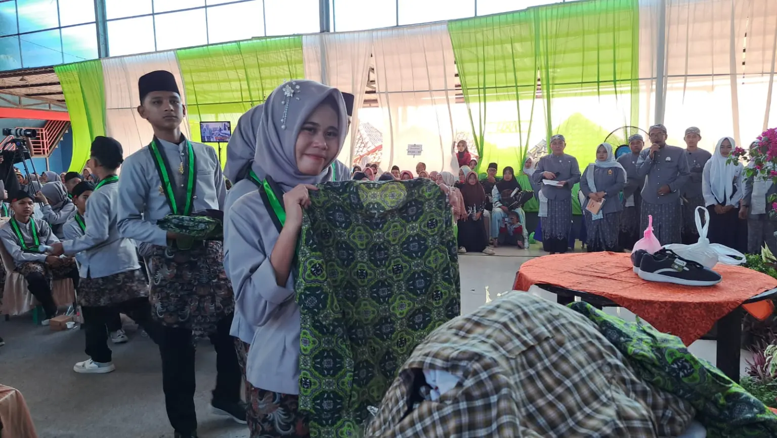 Siswa SMP Sultan Agung Kawunganten Cilacap yang lulus menyerahkan seragam layak pakai kepada kepala sekolah. (Faiz Ardani).